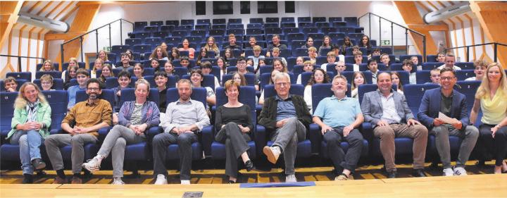 Die Akteure auf der Bühne in der vordersten Reihe, von links: Sylvia Rodel (Schulleitung), Marcelo Duarte (Gemeindekanzlei), die sechs Kandidatinnen und Kandidaten Regula Marthaler, Hans-Peter Budmiger, Marlies Laubacher, Daniel Räber, Jörg Weiss und Herbert Meier sowie die Moderatoren Martin Schneider und Sibylle Merz. Dahinter die Jugendlichen, die viele spannende Fragen stellten. Bild: Annemarie Keusch