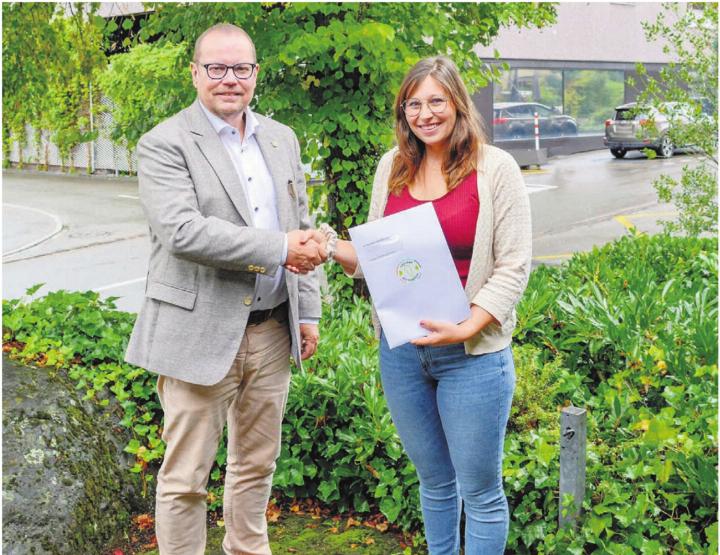 Natasha Kluser aus Benzenschwil freut sich über den Freiämter Ballonfahrt-Gutschein, der ihr von Andreas Gnädinger, Präsident der Wirtschaftskommission des Regionalplanungsverbands Oberes Freiamt, übergeben wird. Bild: zg