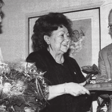 Blumen für den «Chäber» - Ehre, wem Ehre gebührt: Ingrid Fischer (links) und Ulrich Rymann überreichen Wirtin Irma Koch den Rotkreuzpreis.    Bild Archiv: