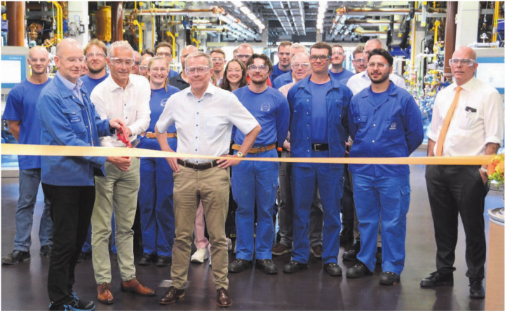 Die neue Produktionsstrasse ist bereits in Betrieb und wird jetzt symbolisch im Beisein des gesamten Teams eingeweiht. Das Band durchschneiden (von links) Betriebsleiter Andreas Brüngger und die beiden Dottiker Gemeinderäte Patrick Keller und Roland Polentarutti, während Firmenboss Markus Blocher (ganz rechts) im Hintergrund bleibt.   Bild: Chregi Hansen