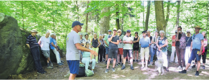 Förster Urs Huber (vorne) referiert bei den Gletscher-Findlingen über den Wald im Wandel.    Bild: Thomas Stöckli